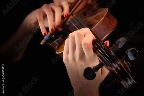 Woman's hands playing the violin in a black background