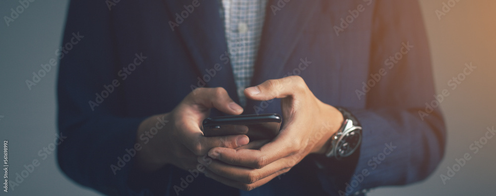 Naklejka premium Businessman using a smartphone in hands. technology concept background.