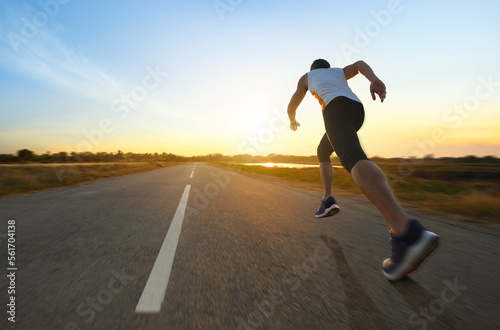 Foto Action motion blur of a man running on country road with sunrise background