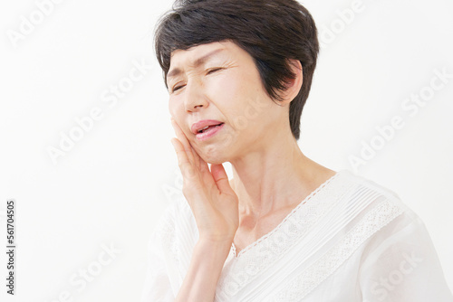 歯が痛い中年女性 白背景