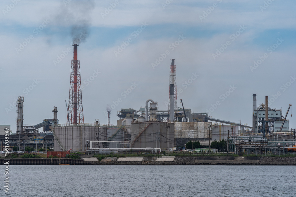 Smoke is coming out of factories chimney near the sea in Kitakyushu city Japan.