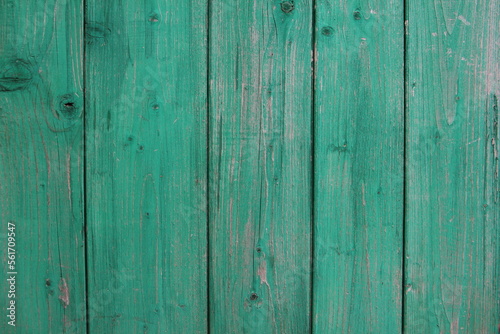 Green old wooden wall with peeling paint, background texture.