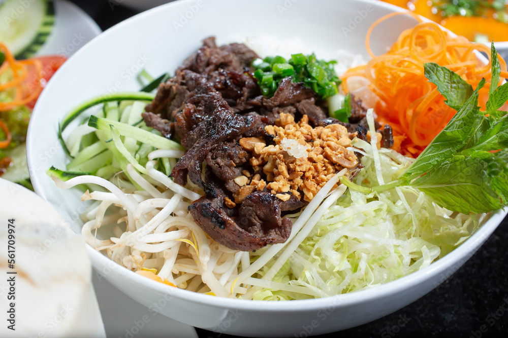 A view of a bowl of Vietnamese bun with marinated beef. A view of a bowl of Vietnamese bun with marinated beef.