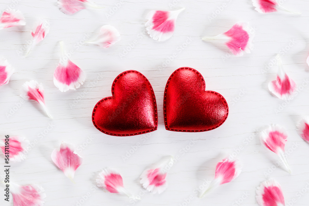 Red hearts and petals on wooden background. Top view.