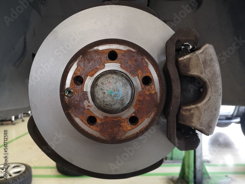 Car brake parts at garage, car disc brakes without wheels closeup