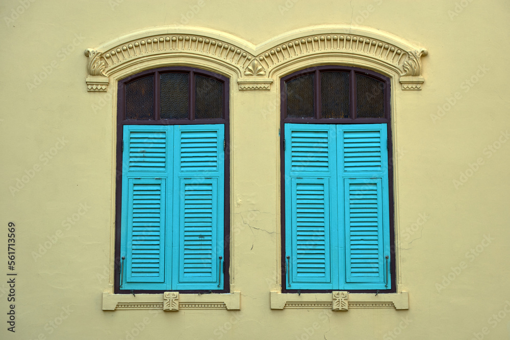 Blue ancient window on a yellow wall