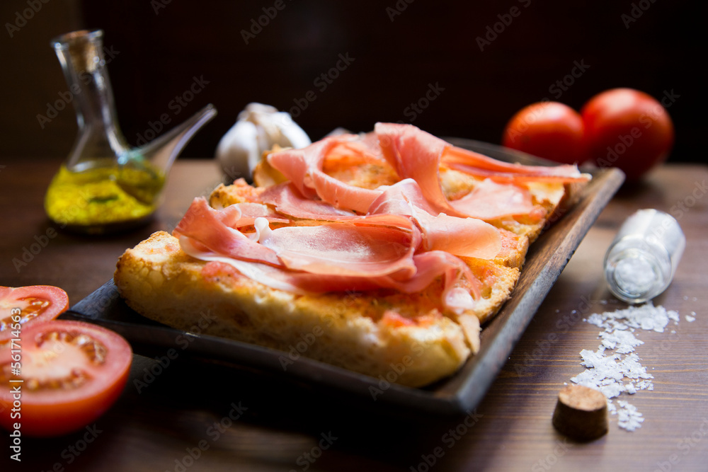 Iberico ham cut into slices. Iberian ham is a type of serrano ham from the Iberian pig, highly regarded in Spanish gastronomy Iberico ham cut into slices. Iberian ham is a type of serrano ham from the Iberian pig, highly regarded in Spanish gastronomy