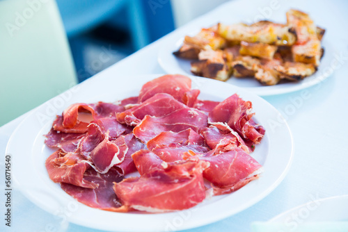 Iberico ham cut into slices. Iberian ham is a type of serrano ham from the Iberian pig, highly regarded in Spanish gastronomy