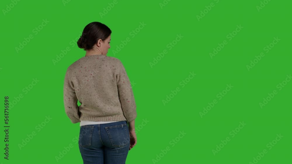 Back view of model being displeased and pushing something sideways, expressing refusal and rejection. Casual person acting discontent and moving object, standing over greenscreen. Back view of model being displeased and pushing something sideways, expressing refusal and rejection. Casual person acting discontent and moving object, standing over greenscreen.