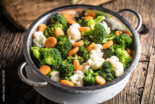 Fototapeta Naklejka Na Ścianę i Meble -  Steamed broccoli, carrots and cauliflower in a stainless steel steamer. Healthy vegetable concept