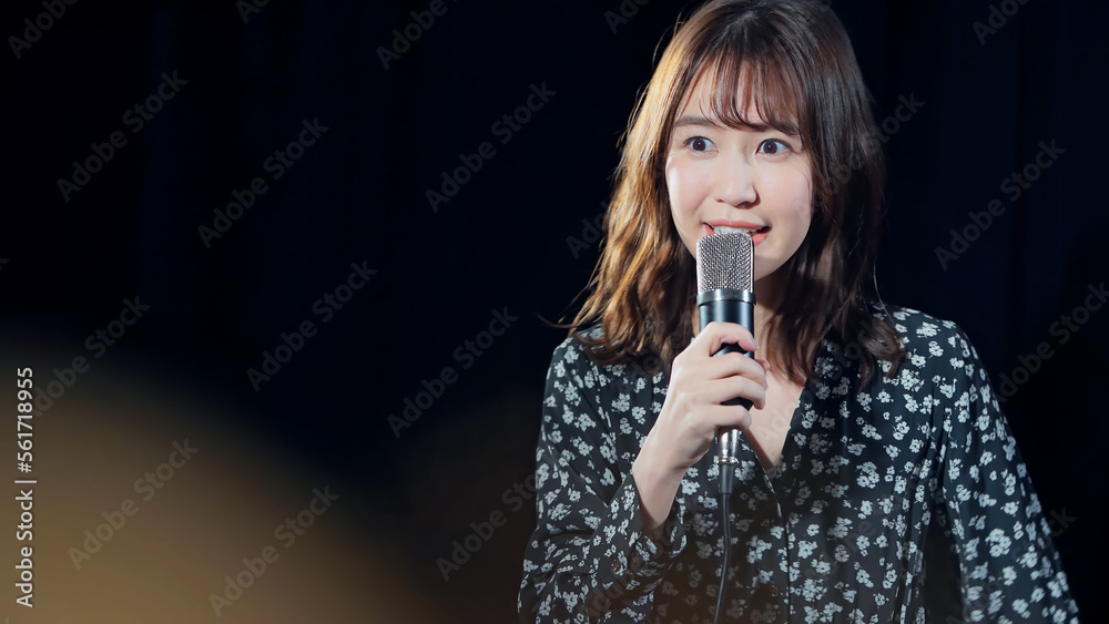 Obraz premium スポットライトを浴びて歌う女性 ライブ コンサート カラオケ