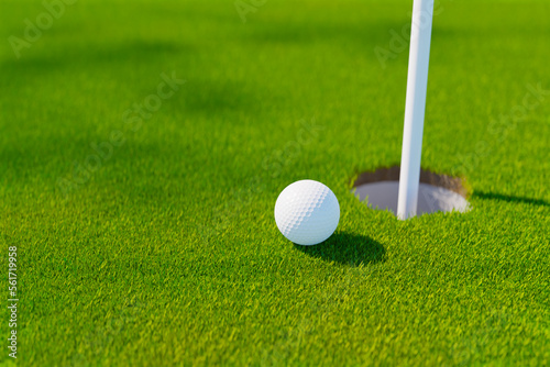 golf ball next golf hole on grass field, 3d rendering