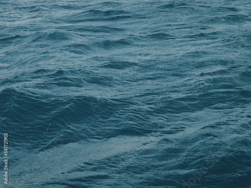 Dark blue-green color of water surface with waves in middle of endless deep sea. Endless wavy expanse of blue sea water. Dark blue waves in deep ocean. Raging aquamarine waves on surface of the water.