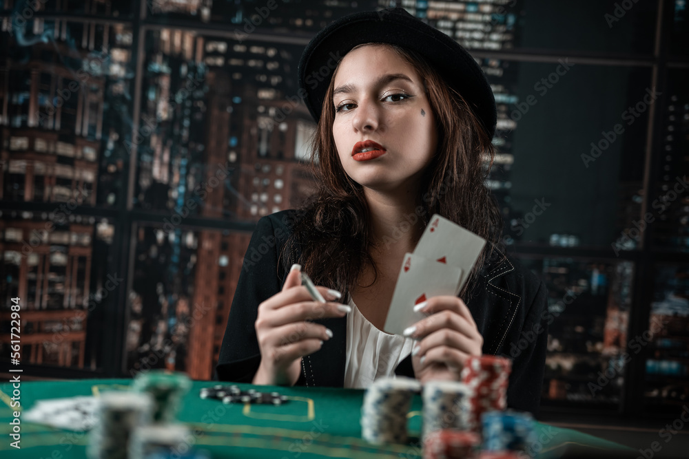 woman's hand takes poker cards at a round poker table. risky bets in poker