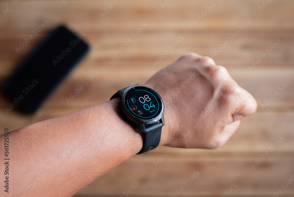 Hand of man wearing smartwach connect to smartphone via healthy application. fitness and healthy concept. Hand of man wearing smartwach connect to smartphone via healthy application. fitness and healthy concept.
