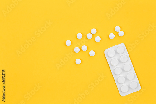 Pills on yellow background, flat lay, conceptual minimalism.