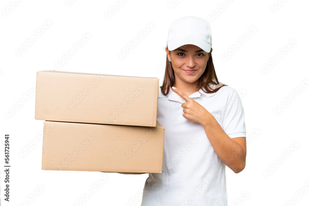 Delivery caucasian woman holding boxes isolated on green chroma background pointing to the side to present a product Delivery caucasian woman holding boxes isolated on green chroma background pointing to the side to present a product