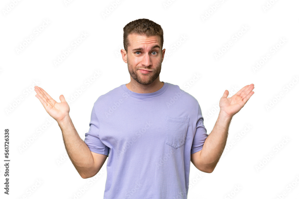 Young handsome caucasian man isolated on green chroma background having doubts while raising hands Young handsome caucasian man isolated on green chroma background having doubts while raising hands