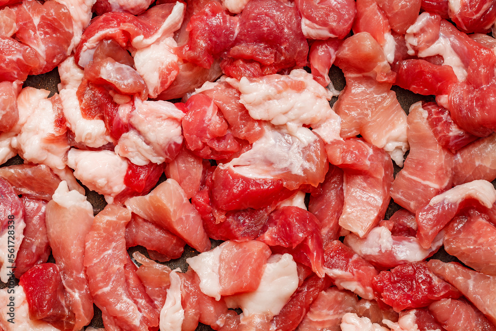 Raw pork meat cut into chunks, preparation for subsequent roasting, close-up, full depth of field