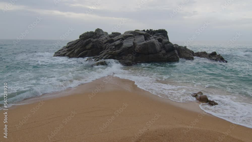 The sea separated in two by sand and rocks, the waves meet and cover the beach, in Spain The sea separated in two by sand and rocks, the waves meet and cover the beach, in Spain