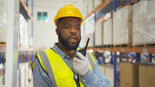 Portrait of black man worker working in large warehouse retail store industry factory. Rack of stock storage. Cargo in ecommerce and logistic concept. Depot. People lifestyle. Shipment service. © tampatra