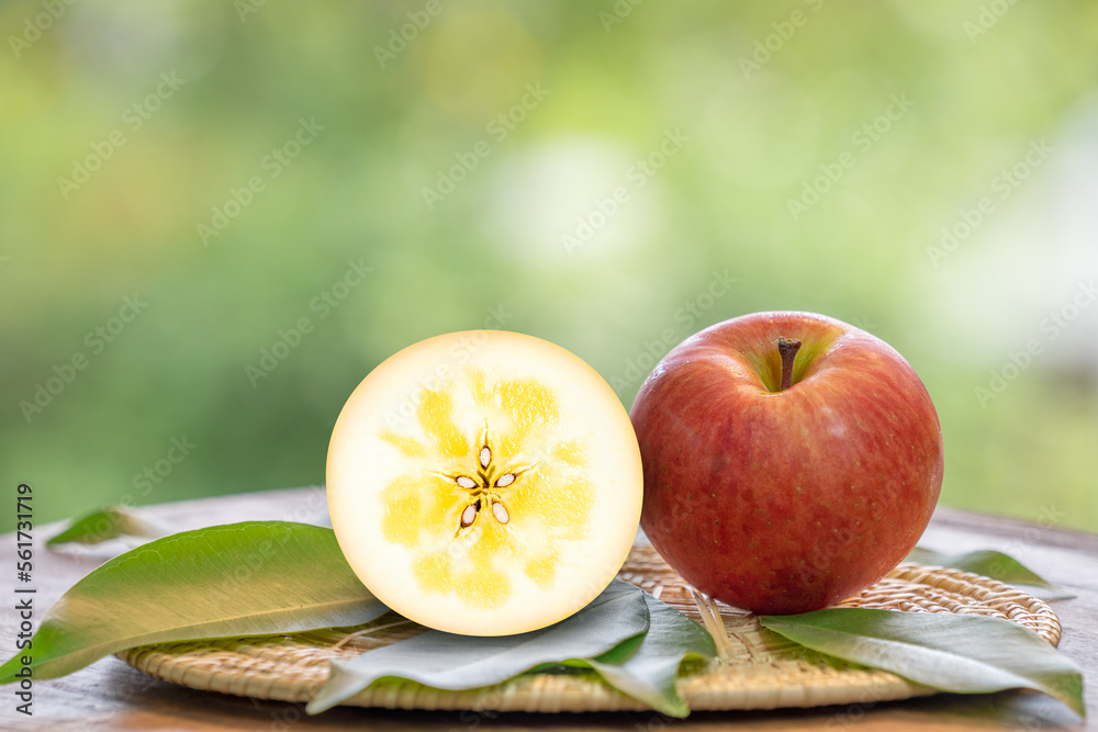 Red Kotoku Apple in the basket over green natural Blur background, Fresh Red Honey core Apple on bamboo mat. . Red Kotoku Apple in the basket over green natural Blur background, Fresh Red Honey core Apple on bamboo mat. .