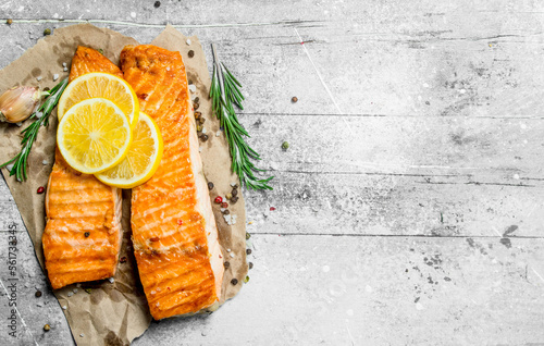 Grilled salmon fillet with slices of fresh lemon.