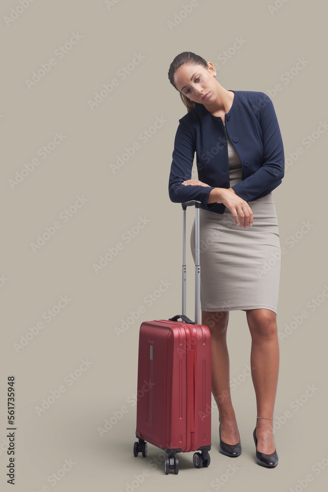 Tired woman waiting with a trolley bag Tired woman waiting with a trolley bag
