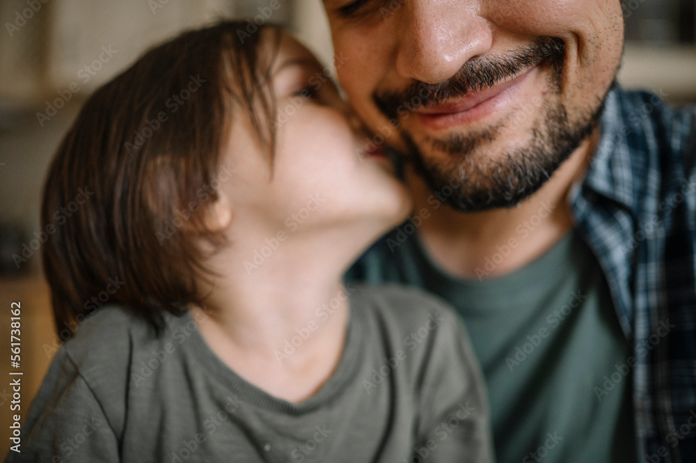 Son kissing father on cheek at home Son kissing father on cheek at home