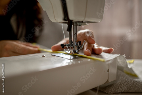 Woman using sewing machine at home photo