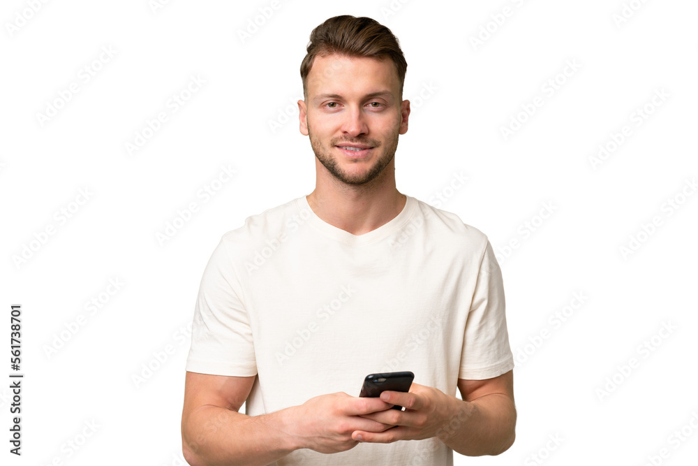 Young blonde caucasian man over isolated background sending a message with the mobile Young blonde caucasian man over isolated background sending a message with the mobile