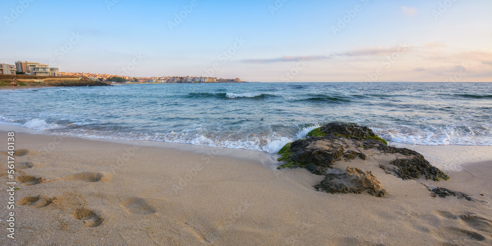 stone on the sandy sea shore. summer holiday season. travel background with clods above horizon