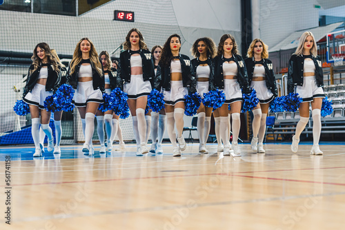 Full shot of cheerleaders walking toward the camera with ble pom-poms in their hands. Sport concept. High quality photo