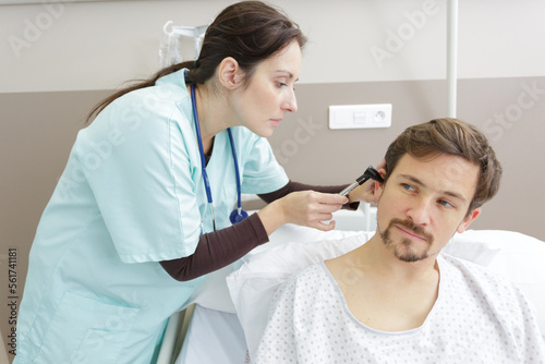 doctor looking in the ear of a patient in hospital