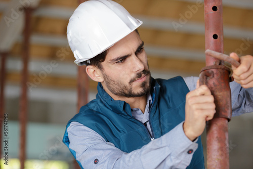 serious builder working with pipes photo