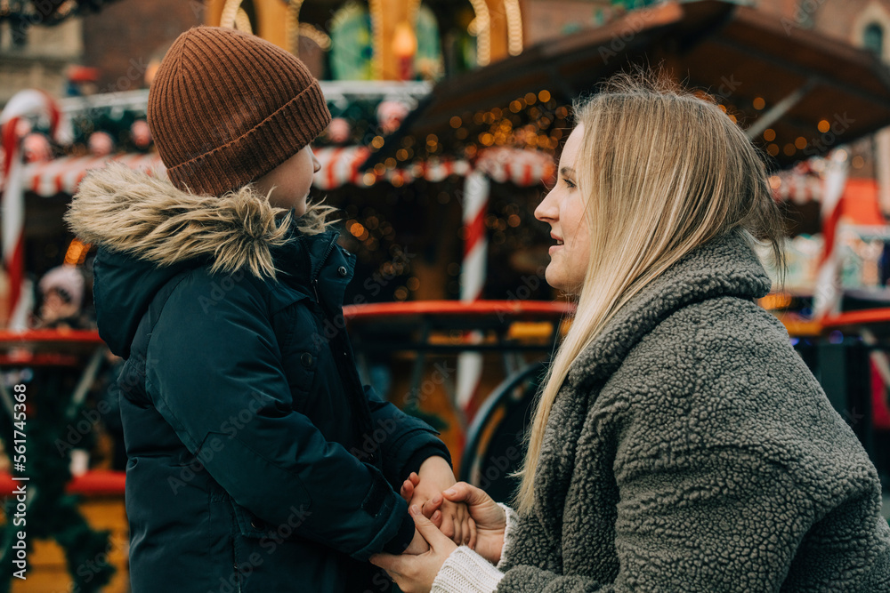 Mother holding hands of son at Christmas market Mother holding hands of son at Christmas market