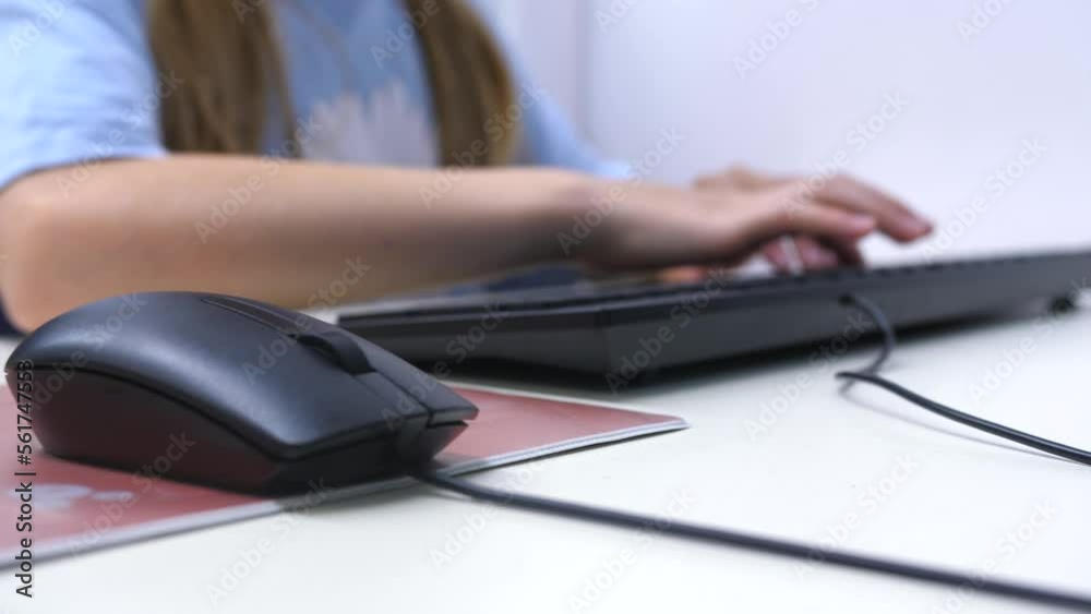 young girl learning to use computer, hand goes from mouse to keyboard, defocus slow motion young girl learning to use computer, hand goes from mouse to keyboard, defocus slow motion