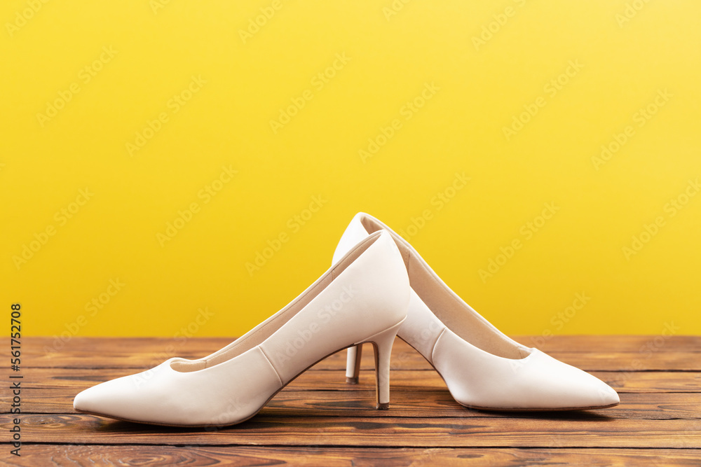 Obraz premium beige shoes on wooden floor on yellow background