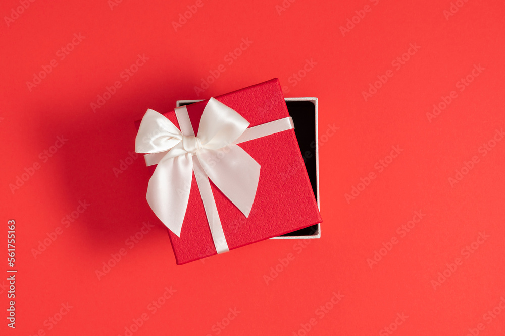 Top view of open red gift box with white bow on red background. Valentine's day, birthday, Christmas, concept, design. Flat lay, copy space Top view of open red gift box with white bow on red background. Valentine's day, birthday, Christmas, concept, design. Flat lay, copy space