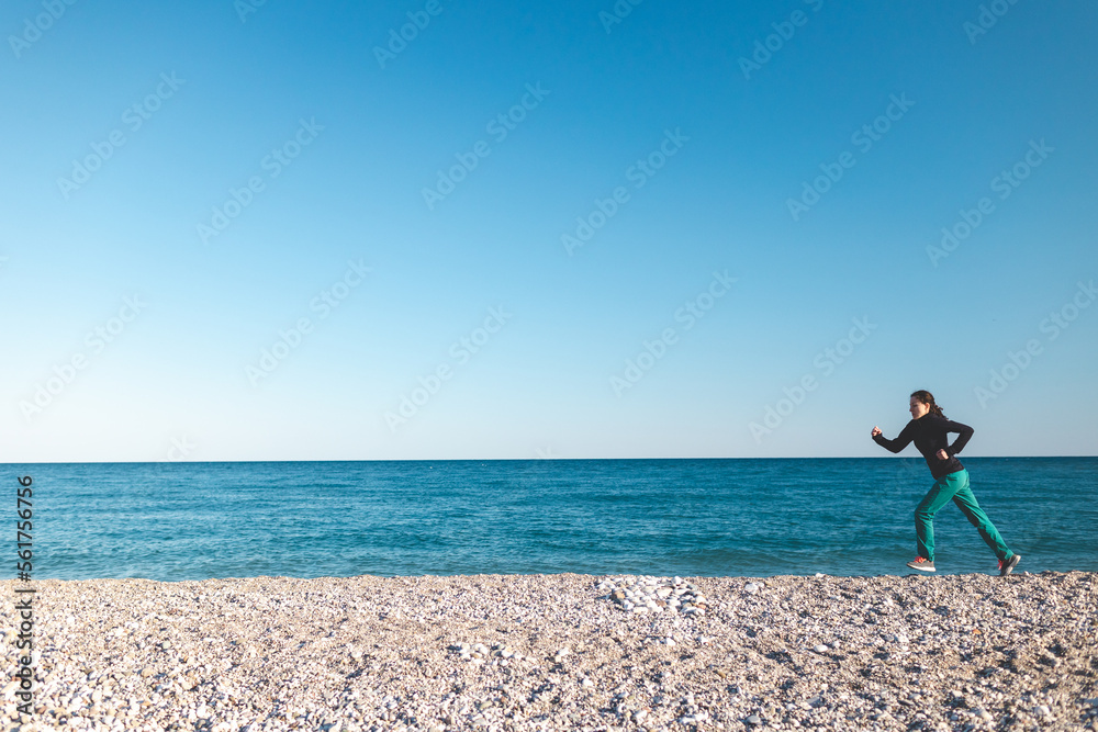 running on the sand, a woman runs along the beach