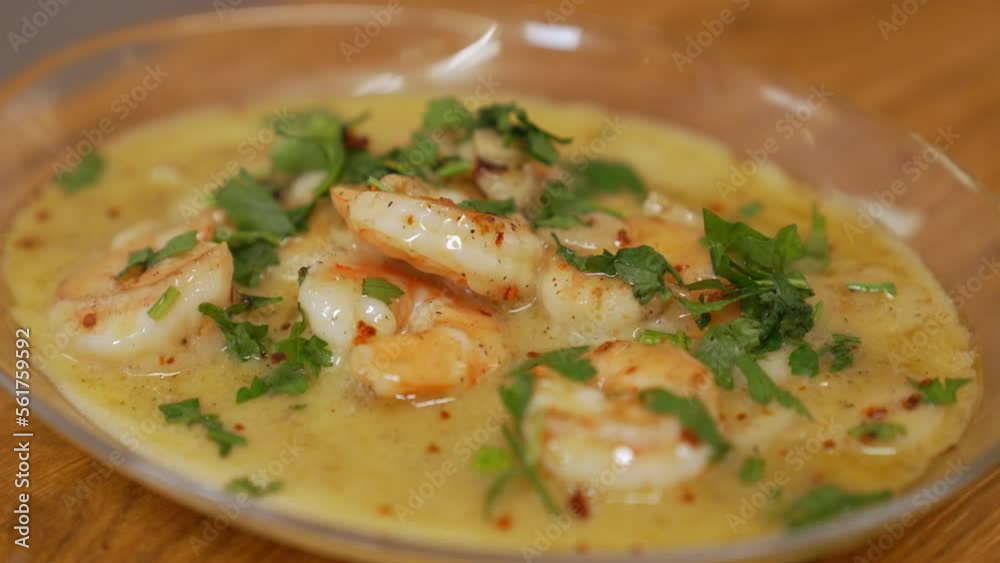 Shrimps in hot sauce. Restaurant dish with the use of seafood. White plate and wooden table. High angle view. High quality 4k footage Shrimps in hot sauce. Restaurant dish with the use of seafood. White plate and wooden table. High angle view. High quality 4k footage