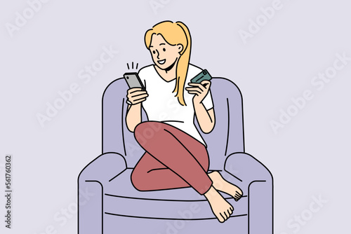 Smiling young woman sit in chair at home shopping online on cellphone with credit card. Happy female buyer purchase goods on internet on smartphone. Vector illustration. 