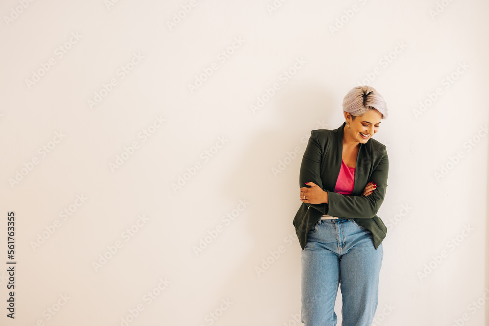 Successful businesswoman smiling happily against an office wall Successful businesswoman smiling happily against an office wall