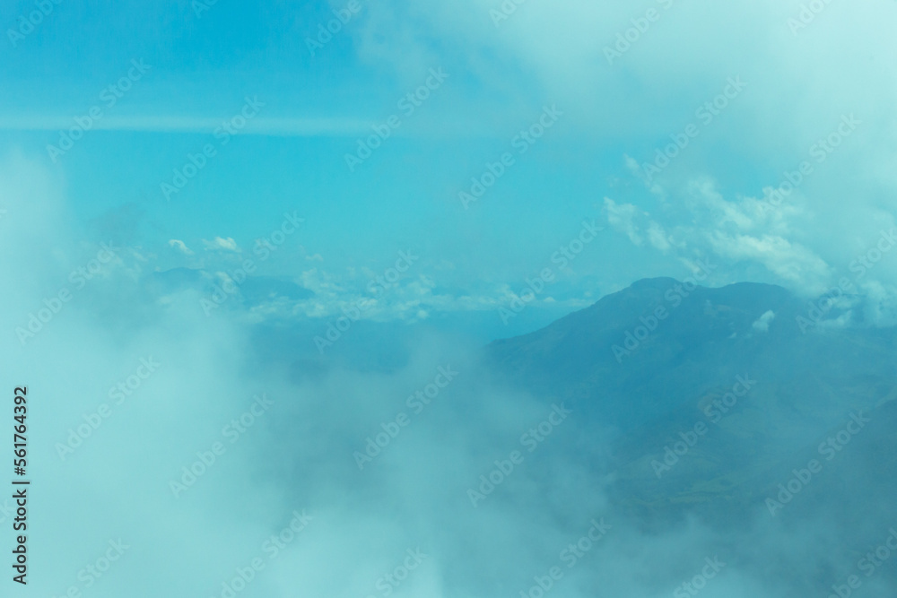 Bright panorama of the cloudy Andes Mountains with a blue sky from the Cerro las Nubes (Mount of the Clouds) in Jerico, Antioquia, Colombia. Very pale white and blue sky.