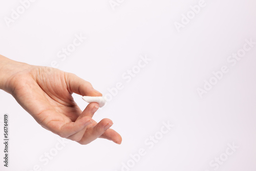 Woman finger with cotton swab after taking blood test. On a white background with a copy space.