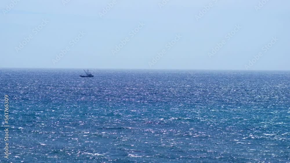 Small fishing boat sailing through waves on horizon. Small fishing boat sailing through waves on horizon.