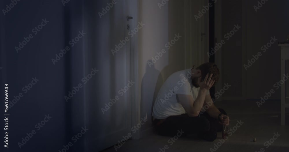 Male man sad and depressed while drinking alcohol at home hallway Male man sad and depressed while drinking alcohol at home hallway
