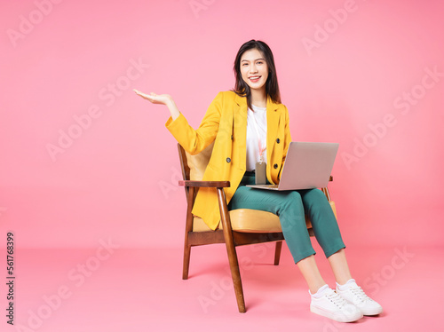 Image of young Asian businesswoman sitting on chair