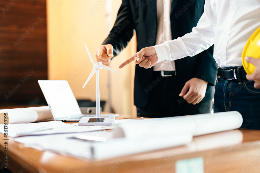 Two engineers or architects attend a business meeting. and pointing to the power turbine The concept of working in clean energy to produce electricity in the future for the world. in work area. Two engineers or architects attend a business meeting. and pointing to the power turbine The concept of working in clean energy to produce electricity in the future for the world. in work area.