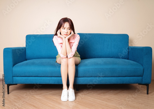 Image of young Asian woman sitting on sofa © Timeimage